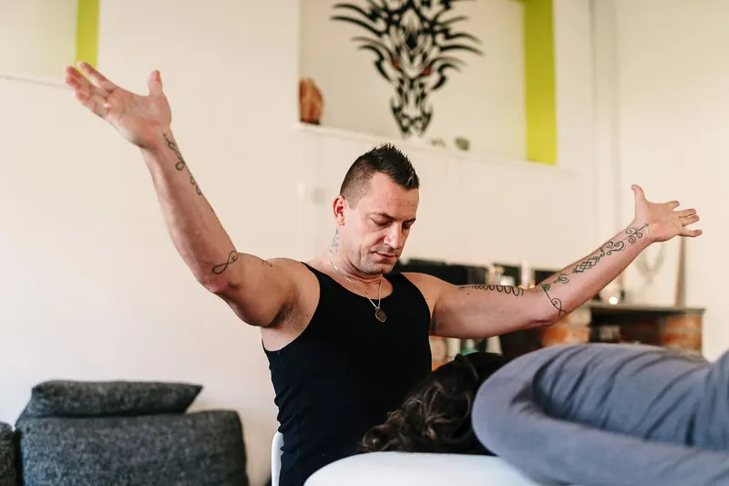 Miran Mišmaš z razprtimi rokami v svojem prostoru v Fari pri Kostelu